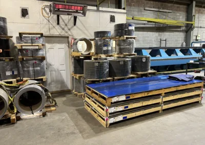 A warehouse storage area with stacked pallets of various industrial materials and products.