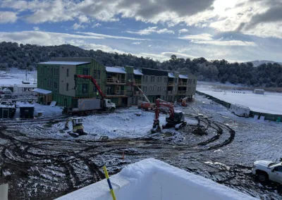 Construction site of a multi-story building covered in snow.