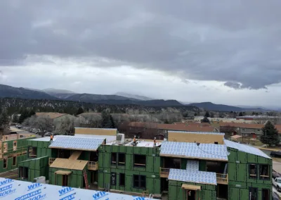 Overcast skies over a residential construction site with surrounding mountainous terrain.